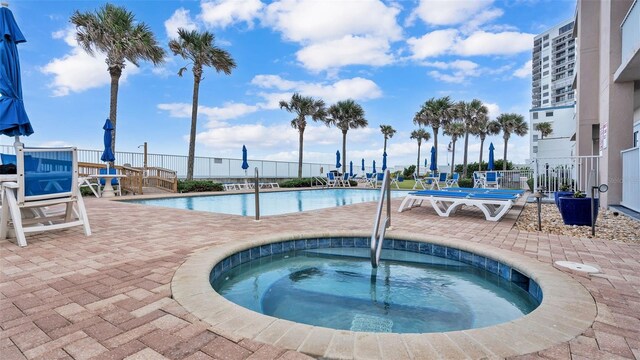 view of pool with a community hot tub and a patio