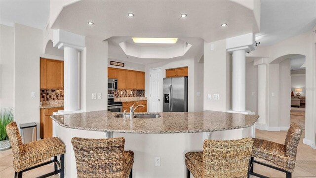 kitchen with backsplash, a raised ceiling, sink, and appliances with stainless steel finishes