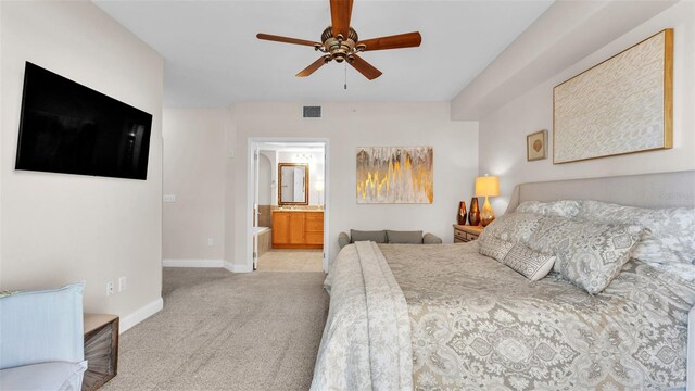 carpeted bedroom with ensuite bathroom and ceiling fan