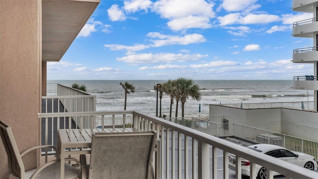 balcony with a water view and a beach view