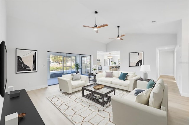 living room featuring light wood-type flooring and high vaulted ceiling