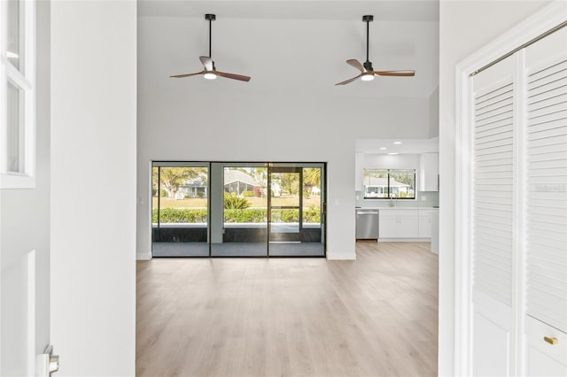 unfurnished living room featuring light hardwood / wood-style flooring and high vaulted ceiling