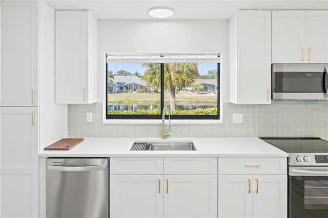 kitchen with white cabinets, appliances with stainless steel finishes, tasteful backsplash, and sink