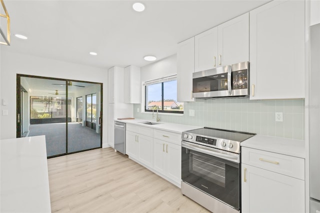 kitchen with backsplash, white cabinetry, sink, and appliances with stainless steel finishes