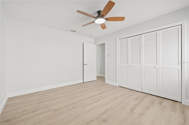 unfurnished bedroom with ceiling fan, a closet, and light wood-type flooring