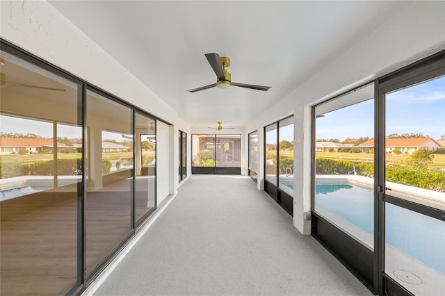 sunroom / solarium featuring ceiling fan, a healthy amount of sunlight, and a water view