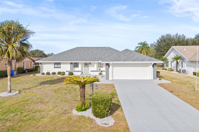 ranch-style house featuring a front yard, a garage, and central AC unit