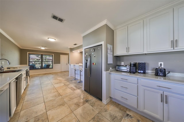 kitchen with stainless steel refrigerator with ice dispenser, crown molding, sink, light tile patterned floors, and white cabinetry