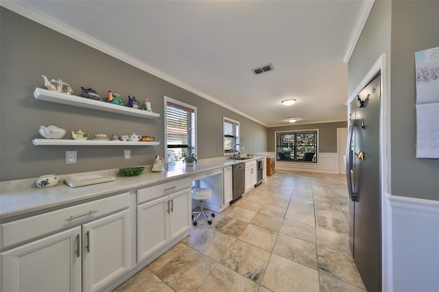 kitchen with sink, white cabinets, ornamental molding, and appliances with stainless steel finishes