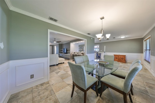 dining space featuring ceiling fan with notable chandelier, a wealth of natural light, and ornamental molding