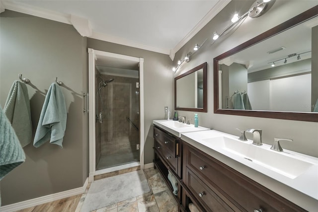 bathroom with vanity, a shower with door, and crown molding