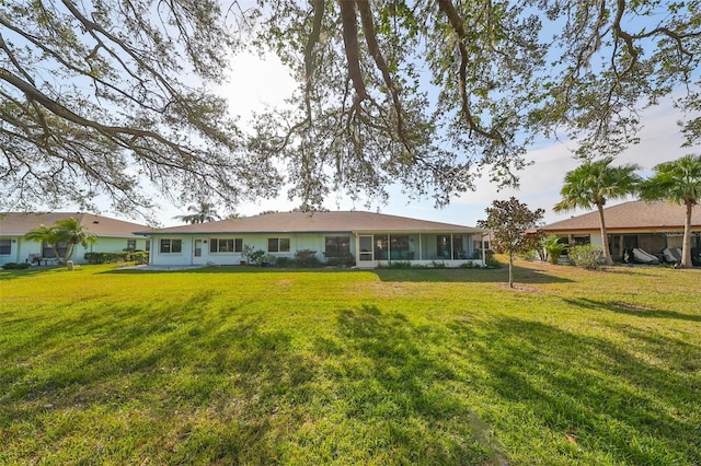 rear view of house featuring a lawn