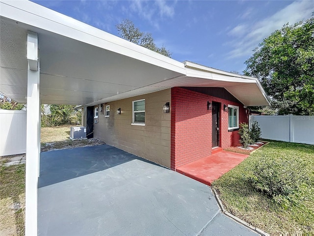 view of home's exterior with a carport, a yard, and central AC unit