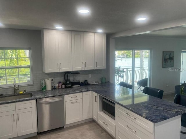 kitchen featuring kitchen peninsula, white cabinetry, sink, and stainless steel appliances