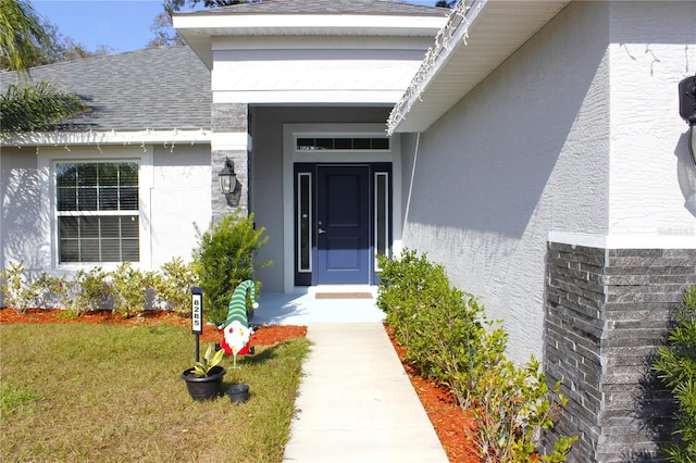 property entrance with a lawn