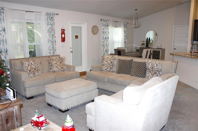 carpeted living room featuring sink and a chandelier