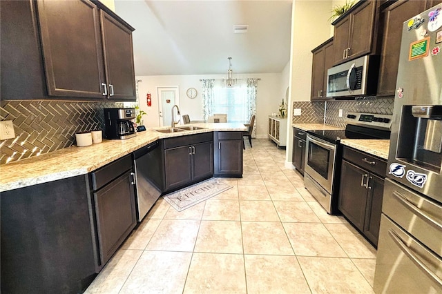 kitchen featuring sink, decorative light fixtures, decorative backsplash, dark brown cabinets, and appliances with stainless steel finishes