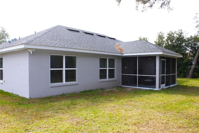 back of house with a sunroom and a yard