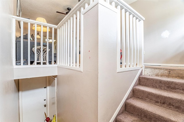 staircase featuring a textured ceiling