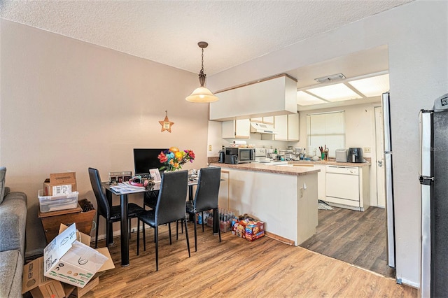 dining space with dark hardwood / wood-style flooring and a textured ceiling