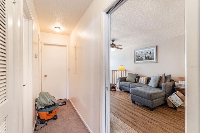 corridor featuring a textured ceiling and light hardwood / wood-style floors