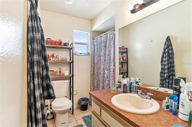 bathroom with tile patterned flooring, vanity, a textured ceiling, and toilet