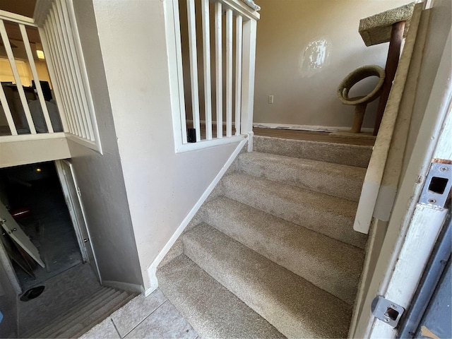 stairway with tile patterned floors and baseboards