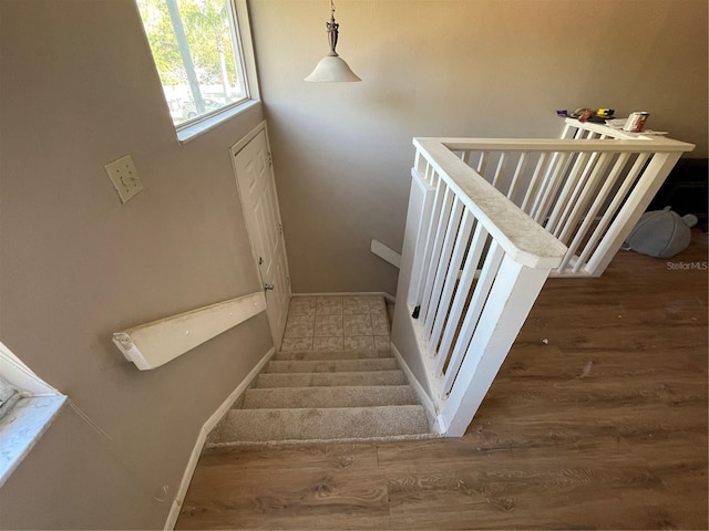 stairway with wood finished floors and baseboards