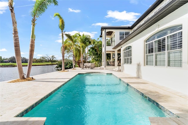 view of pool with a patio and a water view