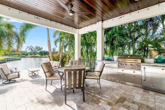 view of patio / terrace with ceiling fan, a water view, a grill, and exterior kitchen