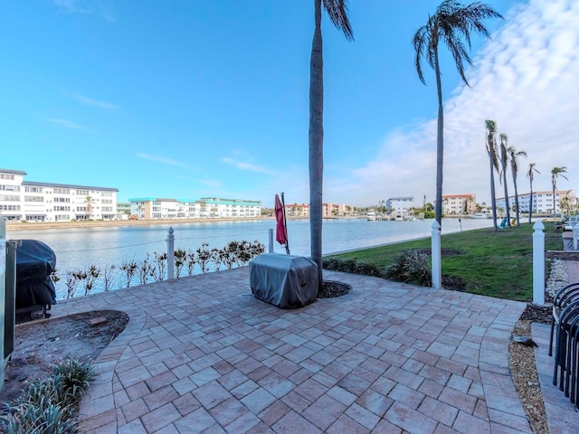 view of patio featuring area for grilling and a water view