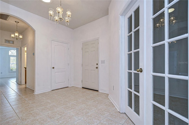 entryway featuring light tile patterned floors and a notable chandelier