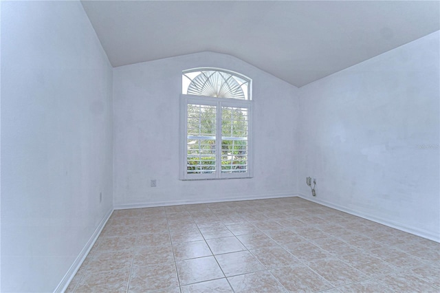 tiled spare room with lofted ceiling