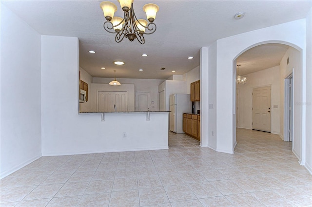 unfurnished living room with light tile patterned floors and an inviting chandelier