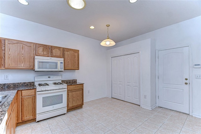 kitchen with light tile patterned floors, decorative light fixtures, and white appliances