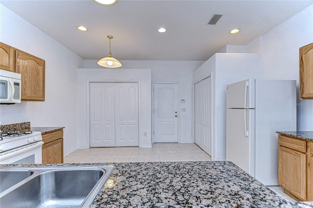 kitchen featuring light tile patterned floors, hanging light fixtures, and white appliances