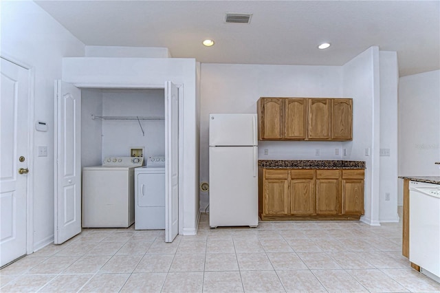 clothes washing area featuring washing machine and dryer and light tile patterned floors