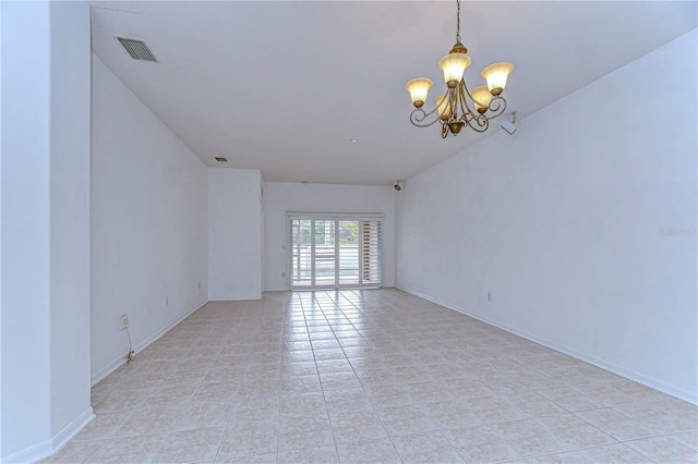 spare room with a chandelier and light tile patterned floors