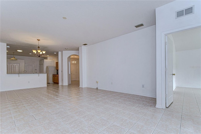 unfurnished living room with light tile patterned floors and an inviting chandelier