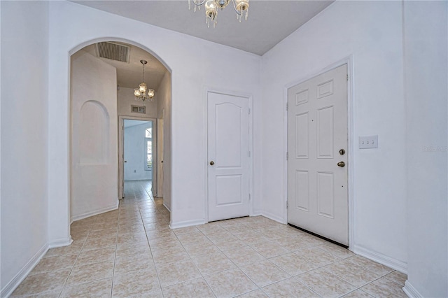 entryway featuring light tile patterned floors and a chandelier