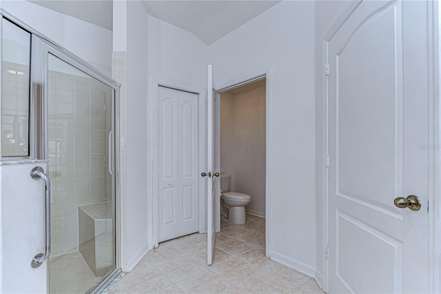 bathroom with tile patterned flooring, an enclosed shower, and toilet