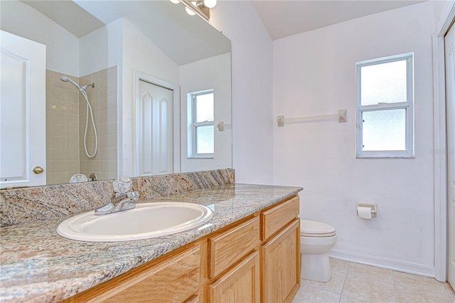 bathroom featuring tile patterned floors, vanity, toilet, and tiled shower