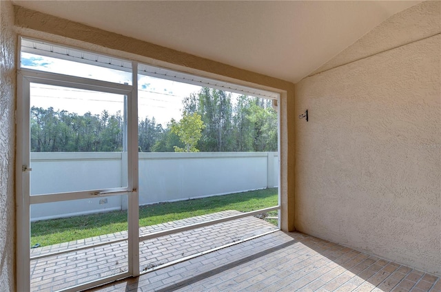 unfurnished sunroom featuring lofted ceiling