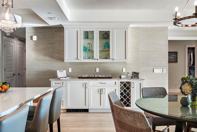 kitchen featuring pendant lighting, white cabinets, and wine cooler