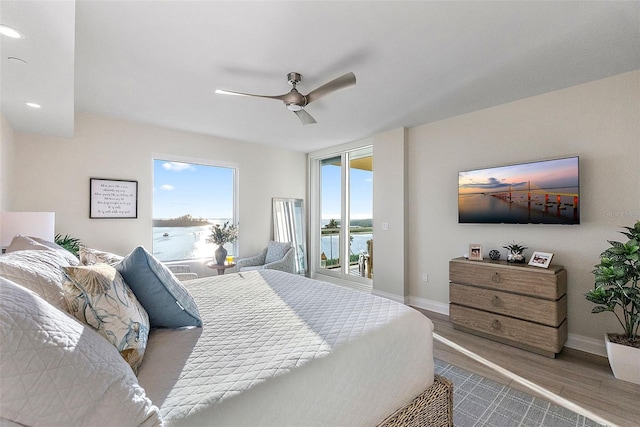 bedroom with access to exterior, wood-type flooring, and ceiling fan