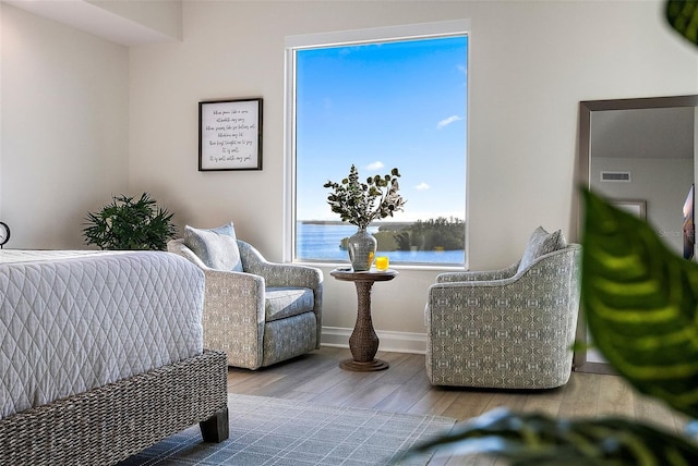 interior space with a water view and light hardwood / wood-style floors