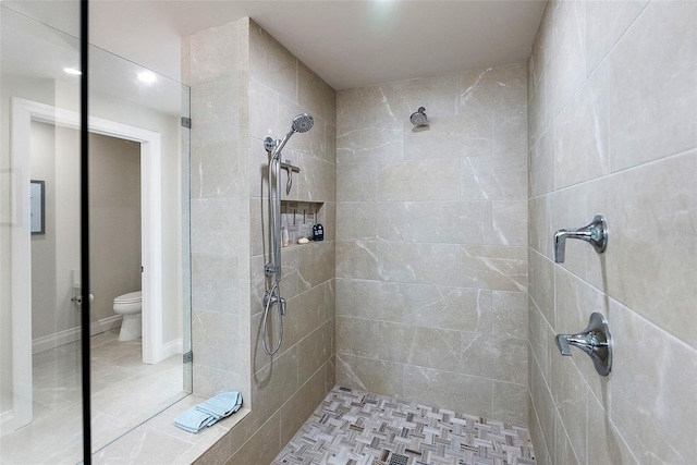 bathroom featuring a tile shower and toilet