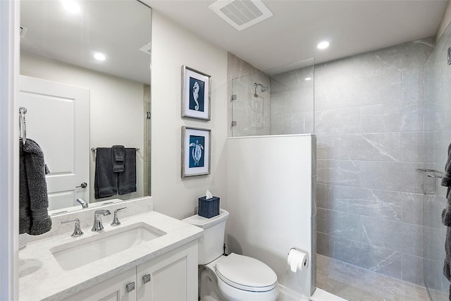 bathroom featuring toilet, vanity, and tiled shower