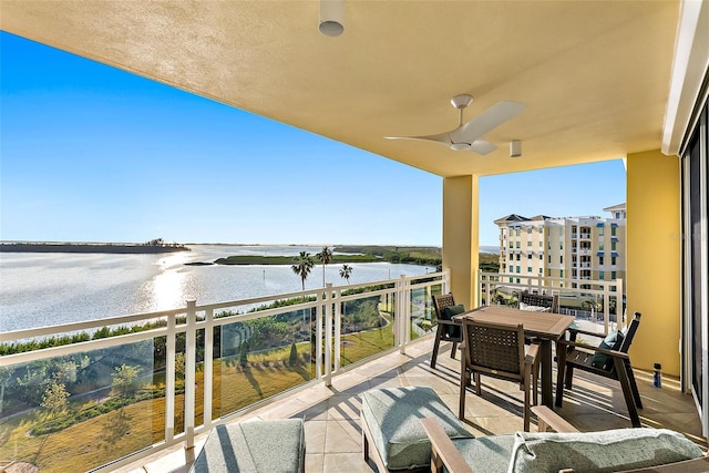 balcony with ceiling fan and a water view