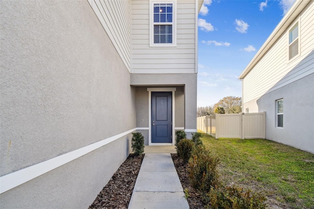 view of exterior entry featuring a yard